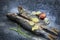 Roasted saury and cut tomatoes on slate background