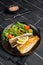 Roasted sea bass fillet with salad, Branzino fish. Black background. Top view