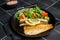 Roasted sea bass fillet with salad, Branzino fish. Black background. Top view