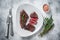 Roasted sliced rump beef meat steak on a plate with thyme. White background. Top view