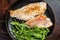 Roasted Snapper, sea red perch fillet on a plate with salad. Dark background. Top view