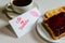 Roasted toast with blueberry jam and black coffe on the white table. Be My Valentine white message card with lips imprint