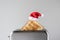 Roasted toast bread in a christmas Santa Claus red hat popping up of stainless steel retro toaster for breakfast preparation.