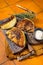 Roasted vegan cabbage steaks with herbs on wooden board. Orange background. Top view