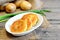 Roasted vegetable cutlets. Potato cutlets with vegetables and spices on plate and on wooden table. Raw potatoes, fresh green onion