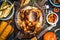 Roasted whole turkey or chicken with organic harvest vegetables and pumpkin for Thanksgiving dinner on rustic table background