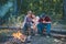 Roasting marshmallows barbecue. Friends camping in forest. Picnic friends. Happy friends on a camping trip relaxing by