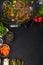 Roasting meat with vegetables, on a black wooden background. Culinary, gastronomy. Vertical frame. Tasty and healthy food