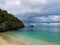 Roatan island Honduras. Landscape of a tropical blue turquoise clear ocean water and sandy beach. Blue dramatic cloudy sky in the