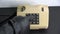 Robber gangster hand with black leather glove pressing numbers buttons on old telephone