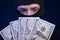 Robber holding money isolated on dark blue