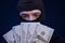 Robber holding money isolated on dark blue