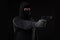 The robber in a mask with a gun pointed to the side on a black background