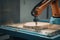 robot arm picks up part from conveyor belt and places it in mold