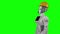 Robot in a builder`s helmet waves hi and talks. Green screen. Side view