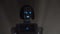 Robot leaves the darkness in the room . Black smoke background. Close up