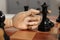 Robot moving chess piece on board, closeup. Wooden hand representing artificial intelligence