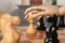 Robot moving chess piece on board, closeup. Wooden hand representing artificial intelligence