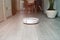 Robot vacuum cleaner cleans the apartment. white robot vacuum cleaner in interior