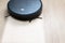 Robot vacuum cleaner cleans the light floor in the living room. Smart cleaning technology