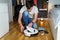 Robot vacuum cleaner repair. Man fixing robot vacuum cleaner DIY at home on the floor. Robotic vacuum cleaner maintenance and