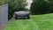 Robotic Lawn Mower Moving Across Lawn, Robot Cuts Green Grass in the Backyard