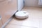 Robotic vacuum cleaner on the floor cleaning the kitchen. Smart cleaning technology.