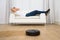 Robotic vacuum cleaner in front of man relaxing