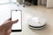 Robotic vacuum cleaner hoovering the floor by mobile application