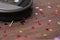 Robotic vacuum cleaner removing confetti from wooden floor, closeup. Space for text