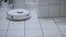 Robotic Vacuum Cleaner Roborock navigating around objects on white bathroom tiles
