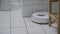 Robotic Vacuum Cleaner Roborock navigating around objects on white bathroom tiles