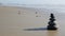 Rock balancing on ocean beach, stones stacking by sea water waves. Pyramid of pebbles on sandy shore