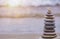 Rock balancing or stone stacking, rock stone or sea pebbles pile or pyramid on sand symbolizing zen, harmony, balance. Ocean water