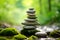 Rock balancing. Stones piled in calming balanced stacks in front of blurry green garden or forest background