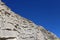 Rock and blue sky, diagonal composition. Geological section. The Caucasus mountains, closeup