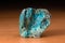 Rock of Chrysocolla mineral from Peru over a wooden table