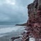 A rock cliff above the water with a tidal shoreline. White sea