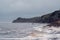 A rock cliff above the water with a tidal shoreline. White sea