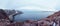 A rock cliff above the water with a tidal shoreline. Wonderful panoramic mountain landscape on the Barents sea. Complex geological