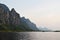 Rock cliff and green forest on limestone mountain on the vast wetland