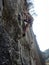 Rock climber climbing granite wall shot from underneath