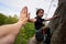 Rock climber climbing overhanging rock with rope. Man helping woman rock climbing. Holding hands.