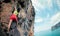 Rock climber climbing on seaside cliff