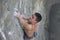 Rock climber clings to an overhang in rock