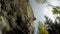 Rock climber descending down the cliff in forest 4k