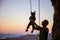 Rock climber giving a swing to his little daughter