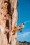 Rock climber hanging on belay rope over the mountains