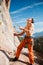 Rock climber holding belay rope over the mountains
