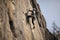 rock climber scaling steep vertical wall with ropes and gear